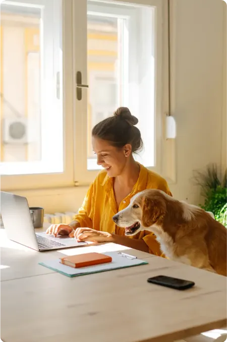 Dame med hund ser på økonomien på PC med Kan